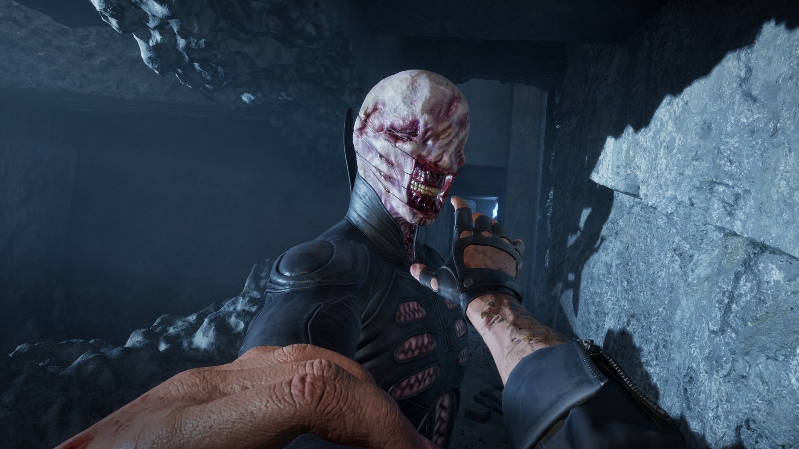 A pale stitched figure with a torn tooth-filled mouth reached toward